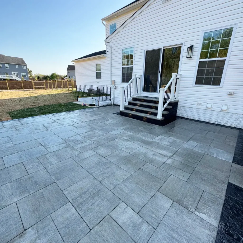 Grey flagstone patio in backyard of white house