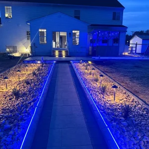 Blue and yellow lighting on back patio and walkway at dusk