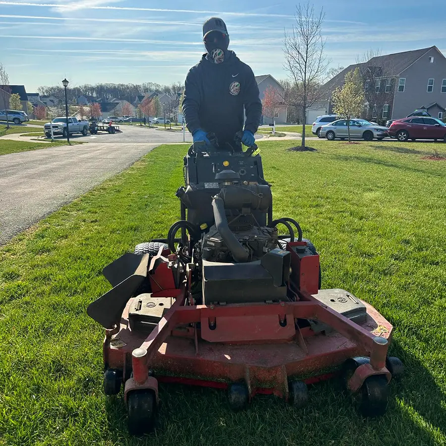 Buho Landscaping using a commercial mower to trim a large lawn in Maryland