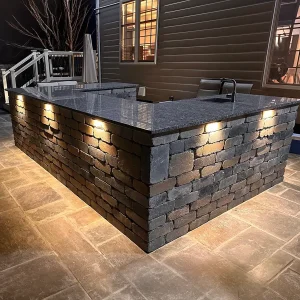 Lighted patio bar with granite countertop at night
