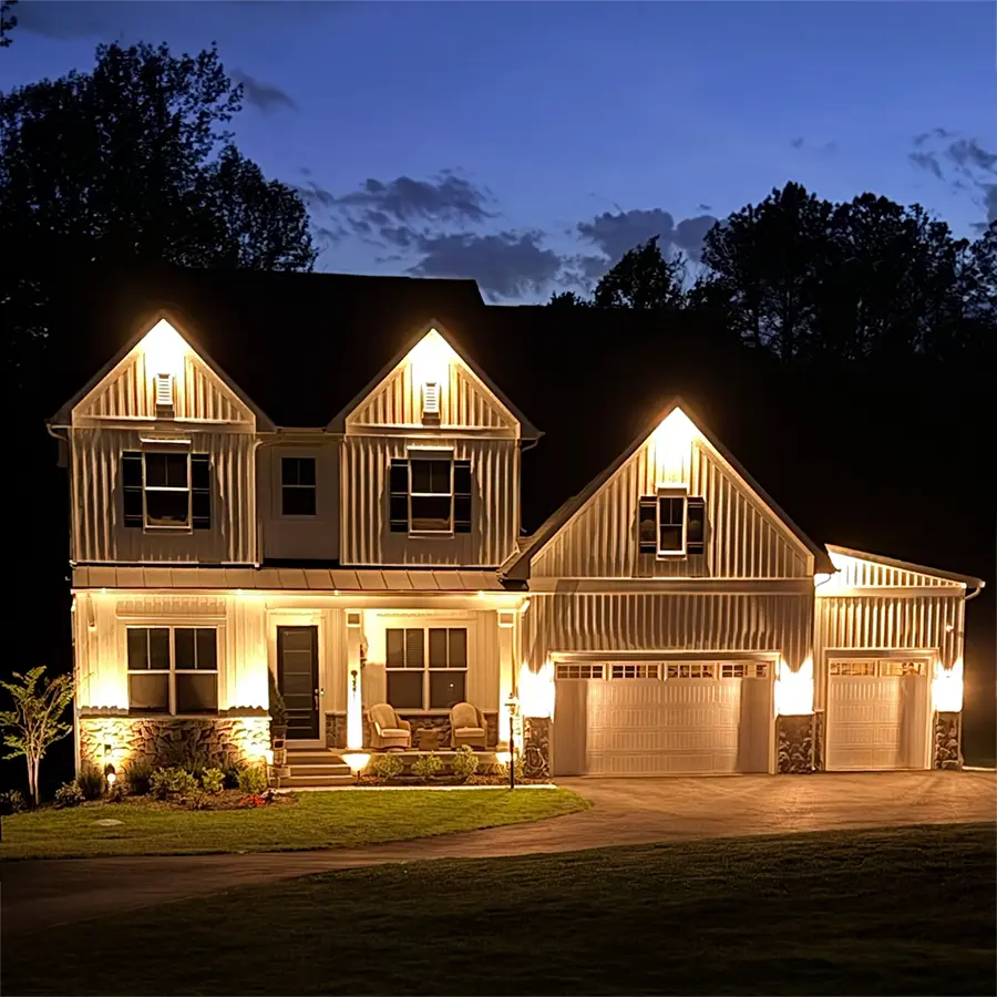 Two story white home with custom outdoor lighting